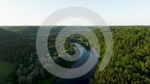 An aerial view A sunny summer evening The Gauja river flows between green forests and a bridge crosses the river.