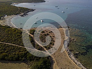 Aerial view at the sunset of Cala Genovese and customs officers trail with moored boats