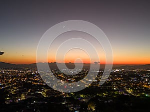 Aerial view of a sunset and half moon over Heredia city, Costa Rica photo