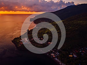 Aerial view of sunset or sunrise and ocean with coastline and mountains in Amed, Bali photo