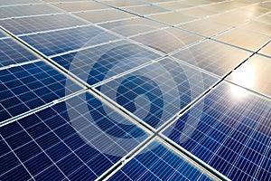 Aerial view of surface of blue photovoltaic solar panels mounted on building roof for producing clean ecological electricity.