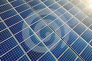 Aerial view of surface of blue photovoltaic solar panels mounted on building roof for producing clean ecological electricity.