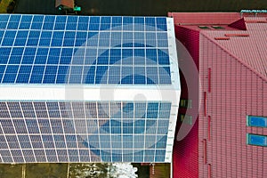 Aerial view of surface of blue photovoltaic solar panels mounted on building roof for producing clean ecological electricity.