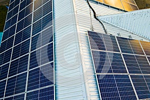 Aerial view of surface of blue photovoltaic solar panels mounted on building roof for producing clean ecological electricity.