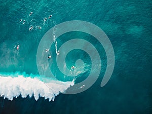 Aerial view with surfers and barrel wave in tropical blue ocean. Top view