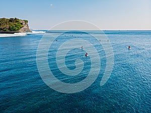 Aerial view of a surfers in blue ocean with waves