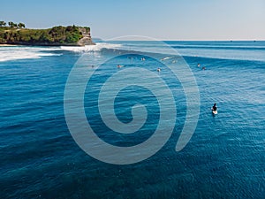 Aerial view of a surfers in blue ocean with waves