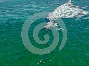 Aerial view of surfers waiting, paddling and enjoying waves