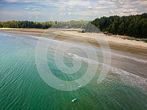 Aerial view of surfers waiting for waves off a tropical beach