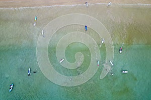 Aerial view of surfers waiting for waves off a tropical beach (Memories Beach, Khao Lak, Thailand