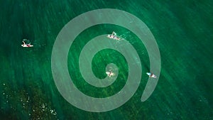 Aerial view of surfers waiting for the waves in the Pacific Ocean`s waters.