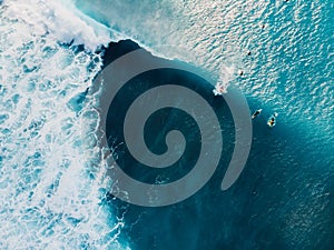 Aerial view with surfers and wave in crystal ocean. Top view