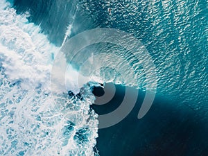 Aerial view with surfers and wave in crystal ocean. Top view