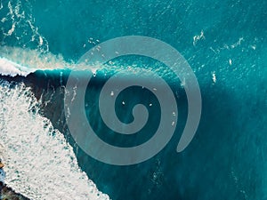 Aerial view with surfers and wave in crystal ocean. Top view