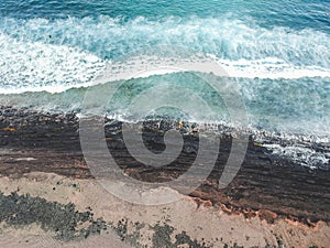 Aerial view of surfers in the waves of the  Atlantic ocean. Sandy beach. Panorama background shot on a drone. Selectivity focus