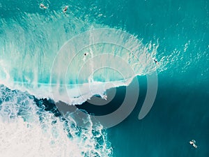 Aerial view of surfing at barrel waves. Blue wave in ocean and surfers