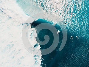 Aerial view of surfing at perfect barrel waves. Blue waves and surfers in ocean