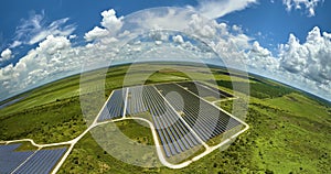 Aerial view of sustainable electric power plant between agricultural farm fields with solar photovoltaic panels for