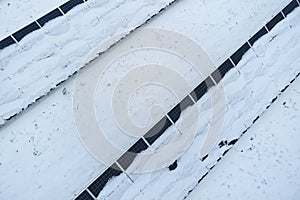 Aerial view of sustainable electrical power plant with solar photovoltaic panels covered with snow in winter for