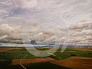 Aerial View Of Sustainable Wind Turbines At The Farmfield In Valdorros In Castile and Leon, Burgos, Spain. wide shot