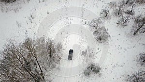 Aerial view of an SUV 6x6 driving on a country road in winter. Top view