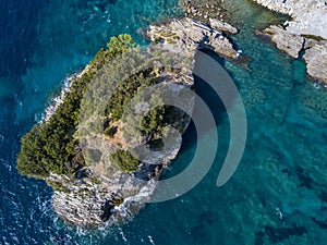 Aerial view of Sveti Nicola, Budva island, Montenegro. Hawaii beach, umbrellas and bathers and crystal clear waters