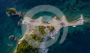 Aerial view of Sveti Nikola, Budva island, Montenegro. Hawaii beach, umbrellas and bathers and crystal clear waters. Jagged coasts