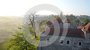 Aerial view of Svirzh castle near Lviv, Ukraine at dawn. Lake, morning fog and surrounding landscape at sunrise.