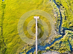 Aerial view of a swamp with a wooden bridge