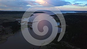 Aerial view of a swampy terrain on a sunset sky background. Clip. Bending river and fields.