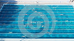 Aerial view of swimming pool with marked lanes and swimmers.