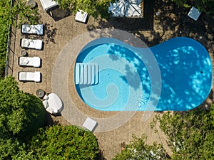 Aerial view of a swimming pool, relaxation and resort, benches and seating.