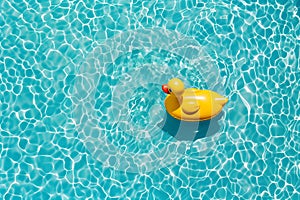 Aerial view of swimming pool transparent turquoise water. Yellow duck float.