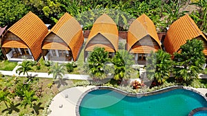 Aerial view of swimming pool in tropical garden in luxury hotel. The pool under Frangipani tree. Luxurious villa resort