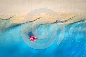 Aerial view of a swimming woman in the sea at sunset