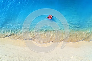 Aerial view of a swimming woman in the sea at sunset