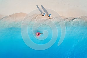 Aerial view of a swimming woman in the sea at sunset