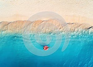 Aerial view of a swimming woman in the sea at sunset