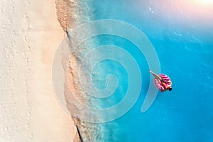 Aerial view of a swimming woman in the sea at sunset