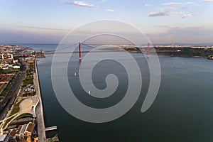 Aerial view of the Tagus River RIo Tejo in the city of Lisbon with sail boats and the 25 of April Bridge on the background;