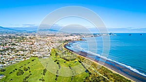 Aerial view on Taranaki coastline with a small river and New Plymouth and Mount Taranaki on the background. New Zealand