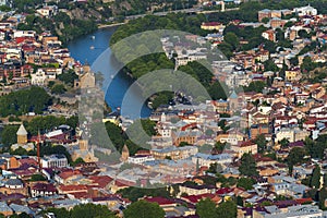 Aerial view Tbilisi Old Town cityscape with ancient houses, trees and  Kura river, Georgia, Europe