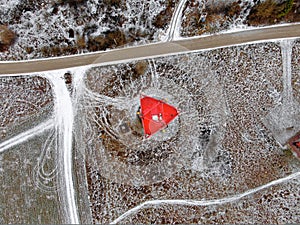 Aerial view telecommunication towers of mobile communication on the background of green field is covered with white snow.