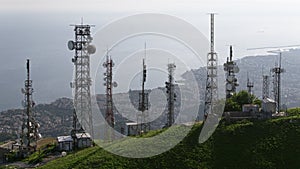 Aerial view of telecommunications towers with antennas and cityscape in the background