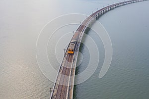 Aerial view of Thai local train on railway bridge at Pa Sak Jolasid Dam, the biggest reservoir in central Thailand, in Lopburi