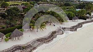 Aerial view of Thatched roof of beach umbrellas of luxury ocean view resort at the beautiful white sand ocean coast in