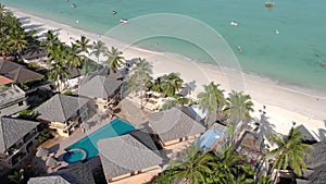 Aerial view of Thatched roof of beach umbrellas of luxury ocean view resort at the beautiful white sand ocean coast in
