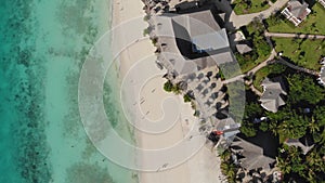 Aerial view of Thatched roof of beach umbrellas of luxury ocean view resort at the beautiful white sand ocean coast in