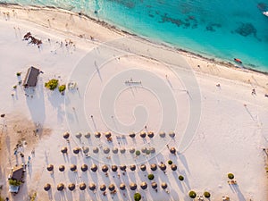 Aerial view of Thatched Roof Umbrellas Pattern on Wide Coastal line of White Sand of Kendwa Beach in Kendwa village