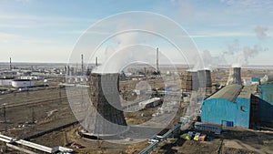 Aerial view of thermal power plant. Drone flies over chimney smoke pipes and cooling towers of industrial area on sunset